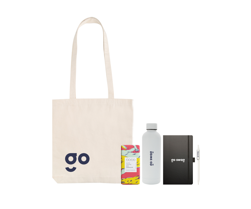 Image depicting an event giveaway pack, comprising tote, bottle, Coco Chocolatier, Castelli Premium Notebook, Metallic finish ballpoint pen, and a custom message card printed on recycled paper